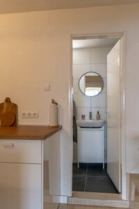 Bathroom entrance with round mirror and sink at Studio Belma Croatia