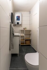 Bathroom with sink, storage shelves and water heater at Studio Belma Croatia