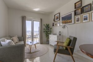 Bright living room Studio Brent Brela with sofa, wall art and balcony access